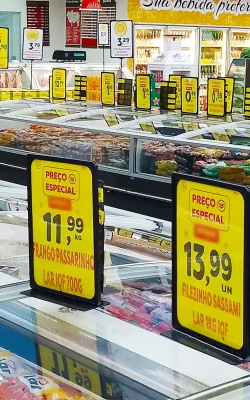 Imagem de gôndolas de congelados em supermercado com sinalização de preços destacados em placas amarelas com a indicação “Preço Especial”.