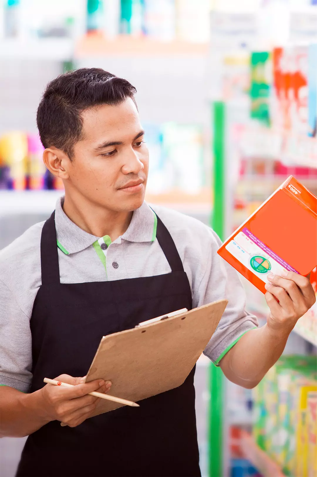 Funcionário conferindo produto com prancheta na mão, representando o controle manual de estoque no pequeno varejo alimentar.