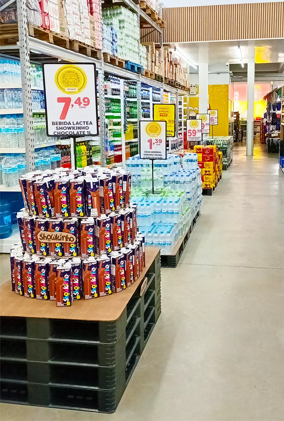 Corredor de supermercado com exibição de produtos e vários cartazes de oferta com preços grandes e visíveis, mostrando como a sinalização impacta as vendas no varejo.