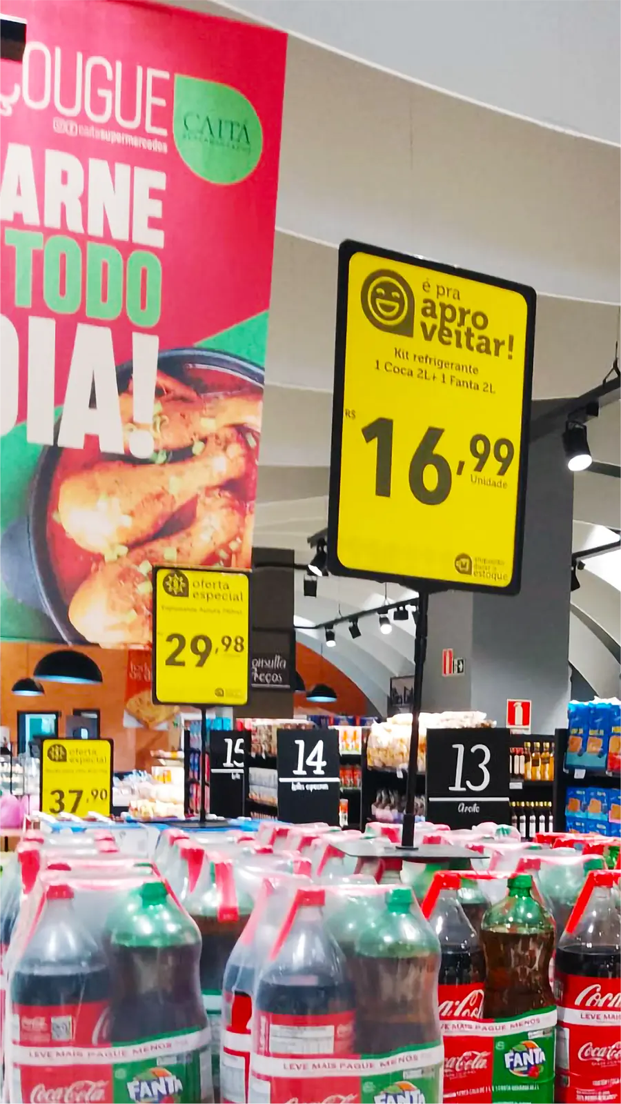 Cartazes promocionais em destaque com preços de refrigerantes Coca-Cola e Fanta 2L em supermercado, reforçando checklist de precificação PDV.