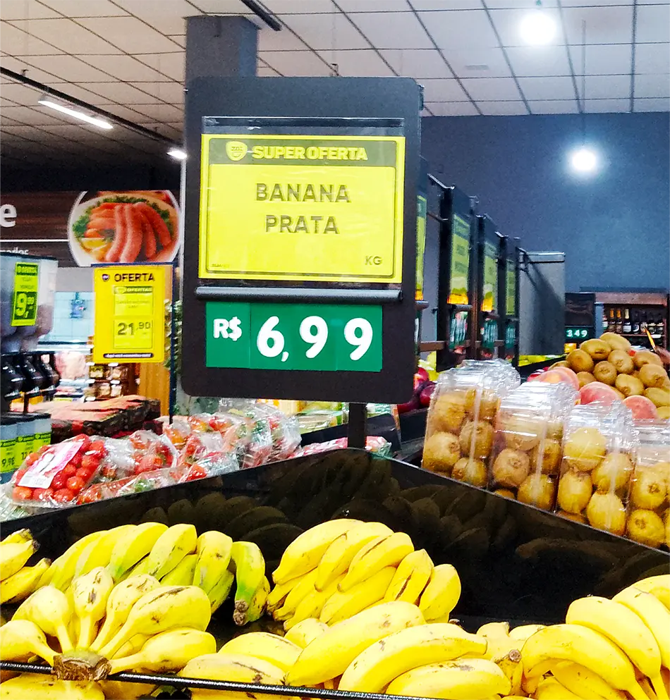 Cartaz de preço para bananas com destaque visual e precificação clara em supermercado, conforme checklist de precificação PDV.