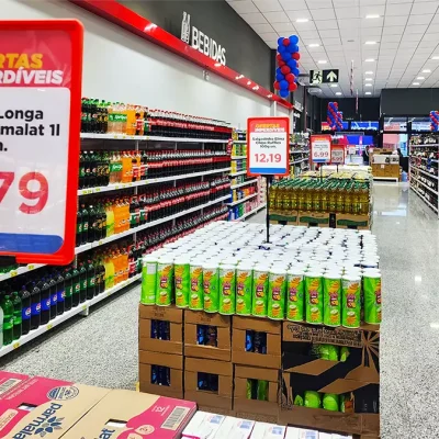 Ilha de ofertas em supermercado com cartazes promocionais e produtos organizados, usada como exemplo de montagem atrativa para impulsionar vendas.