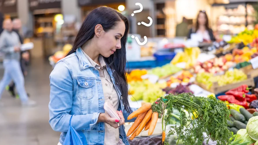 Mulher segurando um maço de cenouras em um mercado, refletindo como a transparência nos preços influencia a decisão de compra.