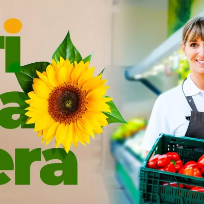 Funcionária de supermercado sorrindo e segurando caixa com pimentões frescos, ao lado da palavra “Primavera” com girassol decorativo, representando a campanha Primavera no Varejo: Torne sua Loja Mais Atrativa.