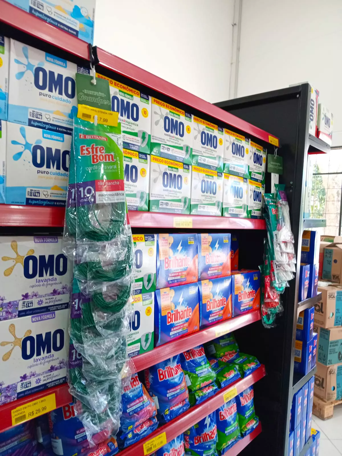 Comunicação Visual e Organização de Gôndolas no Varejo Alimentar Prateleiras de supermercado organizadas com produtos de limpeza e etiquetas de preço, representando a importância da comunicação visual e da exposição no varejo alimentar.