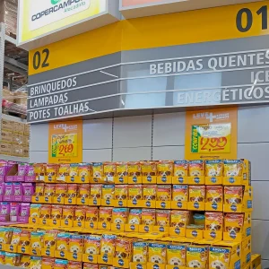 Área de atacarejo com cartazes promocionais e sinalização de corredores, mostrando como Organizar a Comunicação de Preços para Vender Mais com destaque visual e organização de gôndolas.