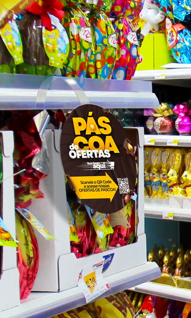 Display de ofertas de Páscoa em supermercado com placa promocional e QR Code incentivando compras e estratégias para vender mais sem depender só de chocolate.